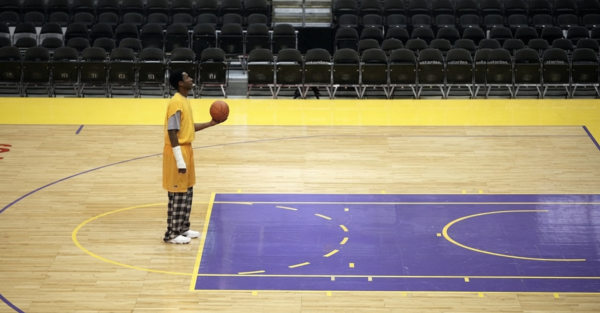 A basketball player standing alone on a court